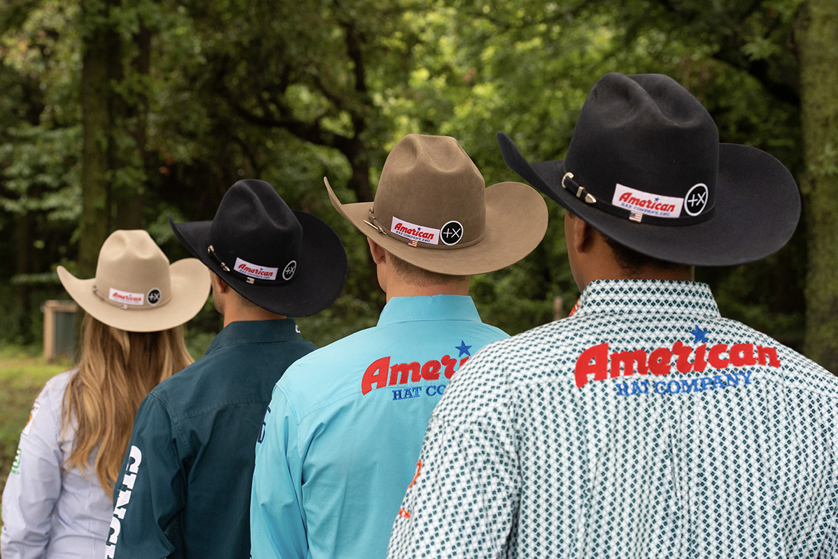 Photo from the back of Jackie Crawford, Shane Hanchey, Tuf Cooper, and Shad Mayfield in a line wearing various color options offered by American Hat Companies felt line.